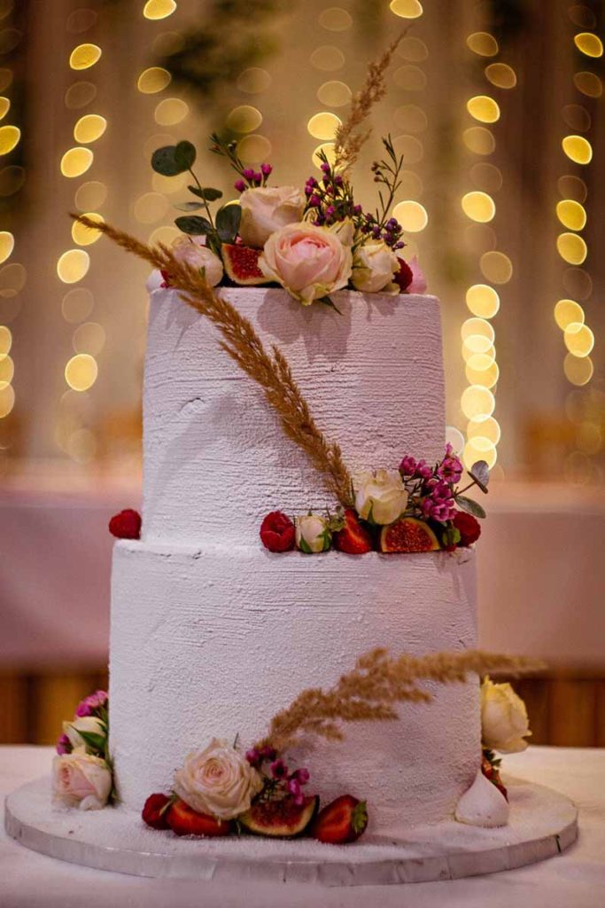 2 tier wedding cake with gold lights in background